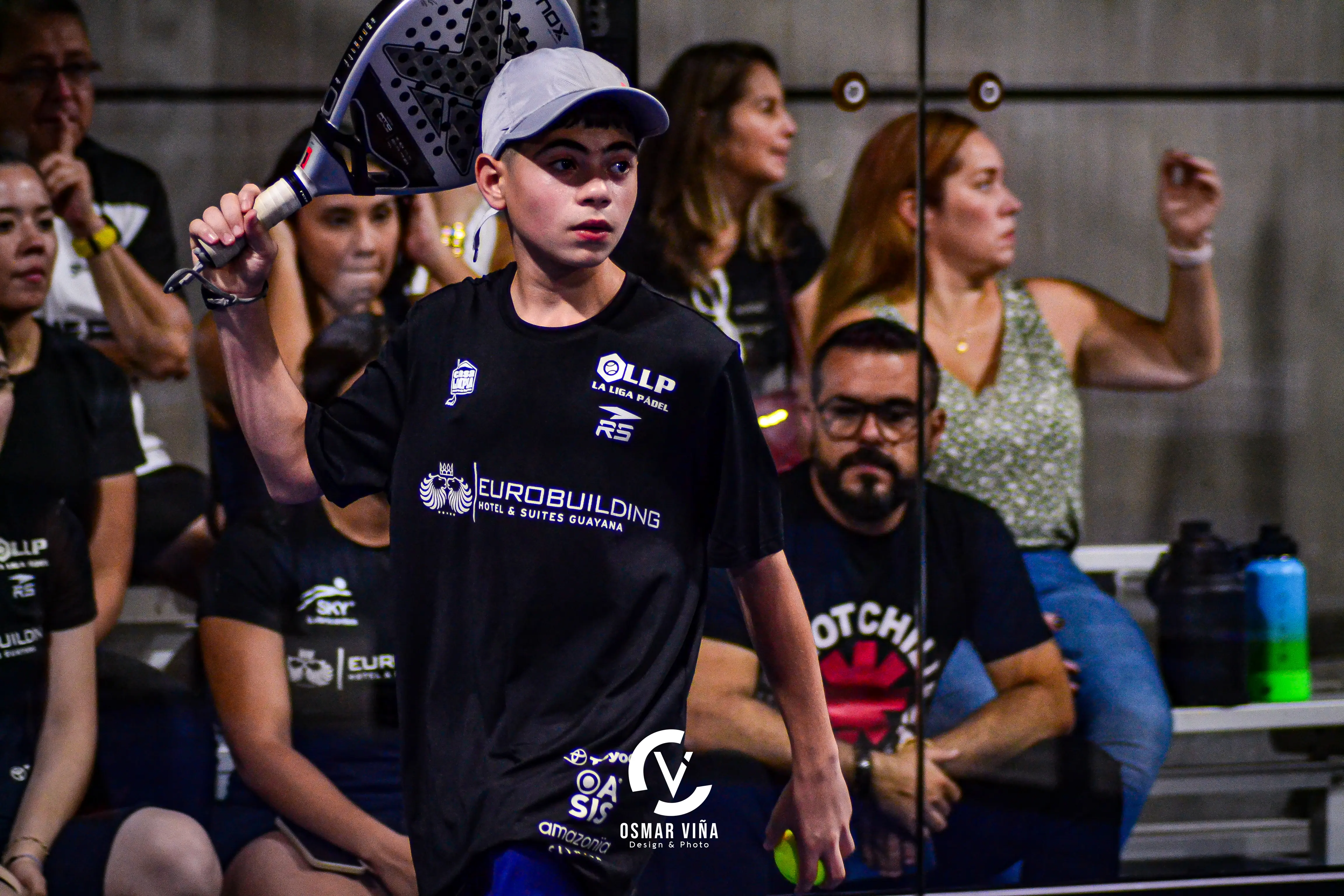 Un adolescente jugando padel.